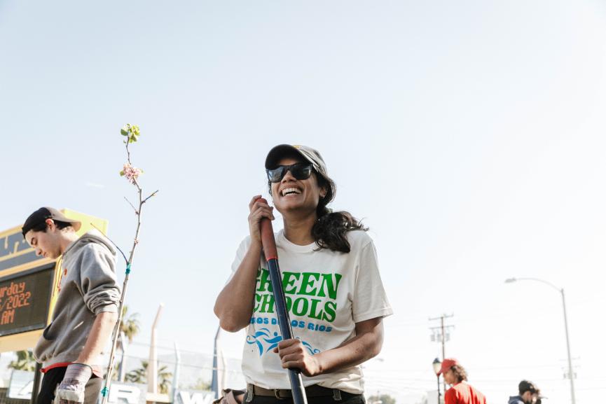 Latin American woman laughing while holding a shovel