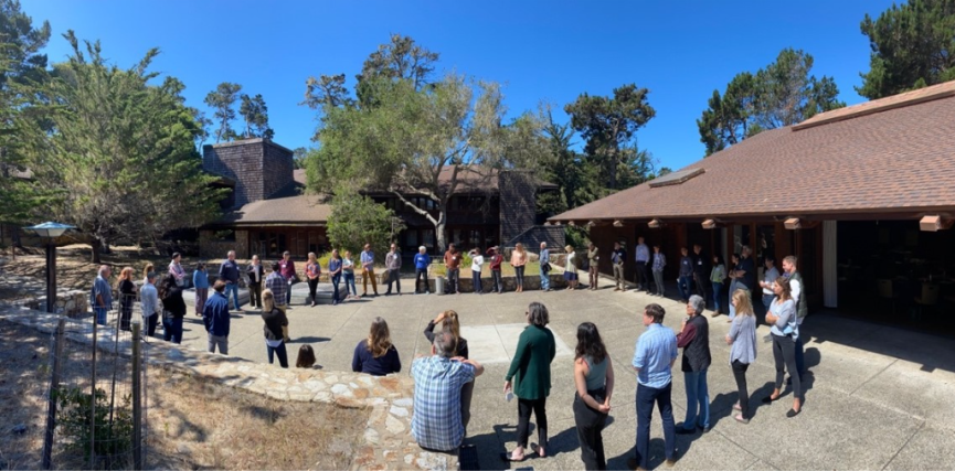 People gathered in a large circle outside in a courtyard