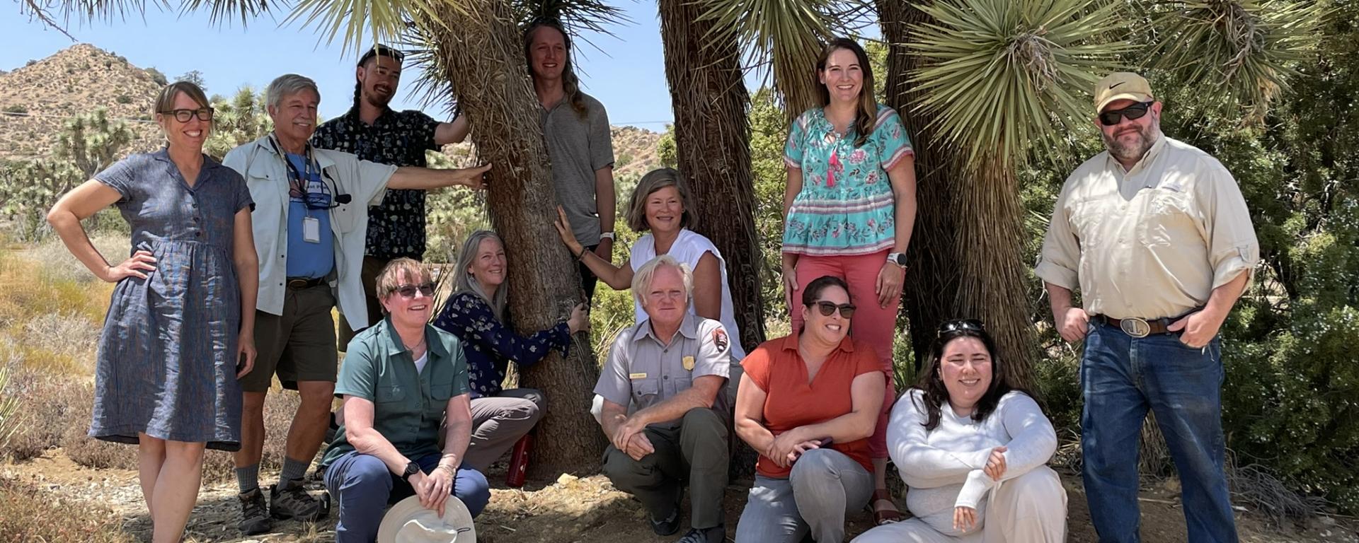 The members of the Joshua Tree Conservation Coalition standing in front of a Joshua Tree